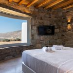 En-suite bedroom with stone walls and stunning sea view