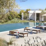 Pool deck with sun loungers and blossoming trees