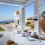 Dine under the shaded pergola overlooking the Aegean Sea