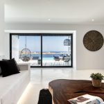 Glass doors opening to the infinity pool overlooking Psarou beach