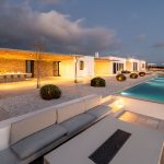 seating area with fireplace by the pool at villa Faragas